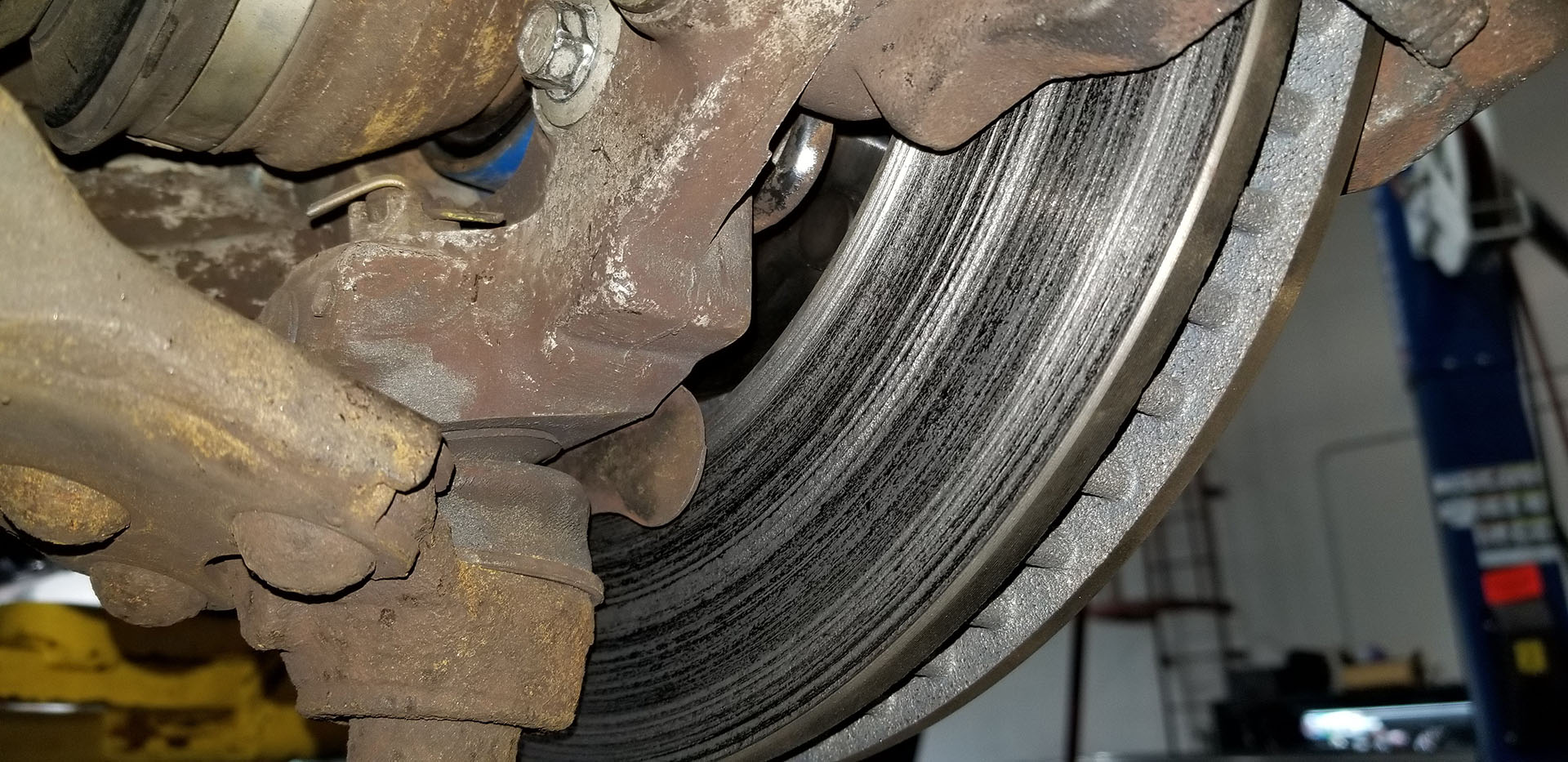 Technician checking vehicle braking components