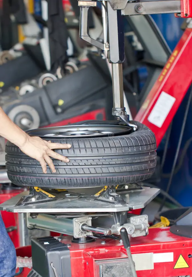 Technician inspecting vehicle brakes and tires